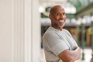 Man in gray shirt smiling outside