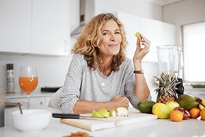Woman smiling while enjoying snack in kitchen
