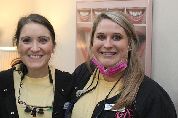 Two smiling dental team members