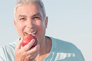 Mature man enjoying an apple.