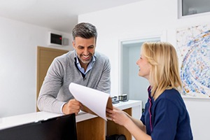 Dental team member assisting patient at front desk
