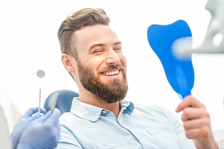 Man looking at smile in mirror