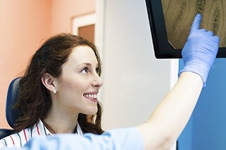 Woman and dentist looking at images on computer screen