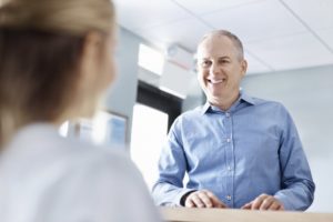 A man speaking with a dental employee.