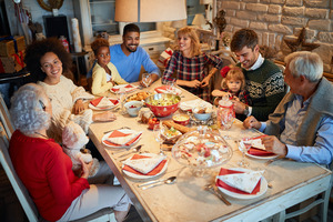 Family at table laughing and enjoying holiday meal